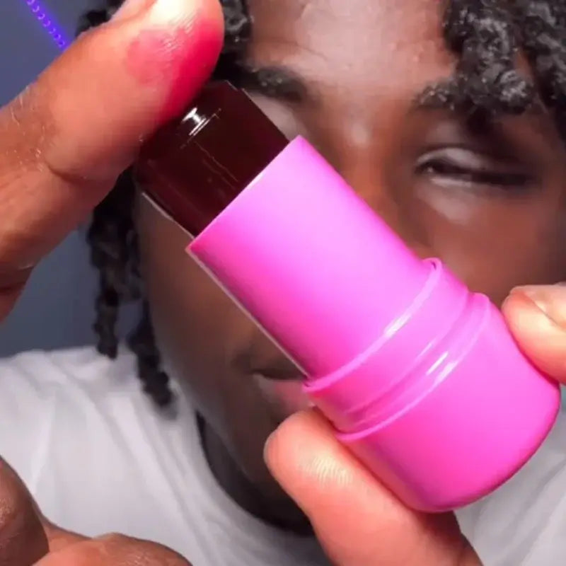 Close-up of a person holding a pink Cooling Water Milk Jelly Tint stick, showcasing its hydrating gel formula.